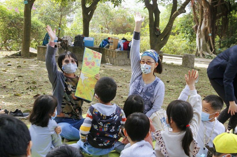 Lin Da Xiang invites participants to read picture books together on the grass.